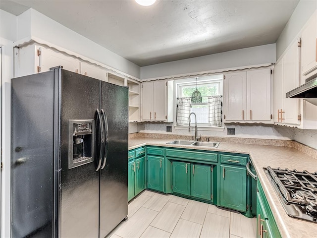 kitchen with black fridge, a sink, gas cooktop, open shelves, and light countertops