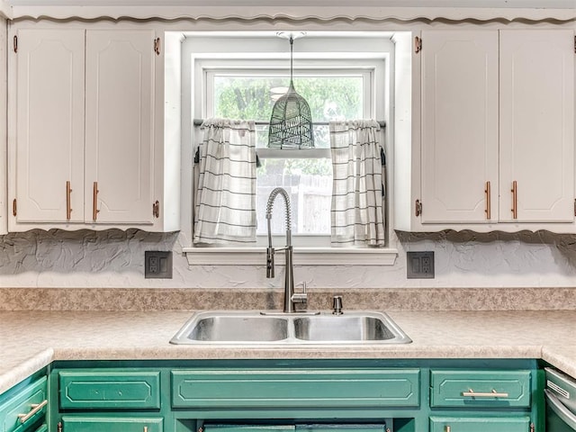 kitchen featuring a sink, white cabinets, light countertops, and stainless steel dishwasher