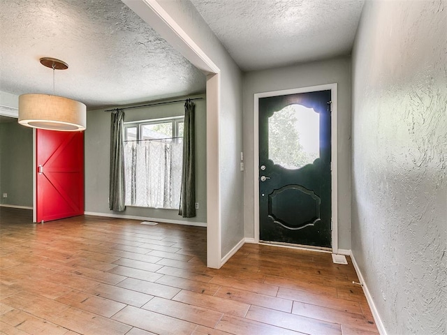 2916 Prairie Rose Ct, Oklahoma City, OK 73120 - entrance foyer featuring a textured ceiling, wood finished floors, a textured wall, and baseboards