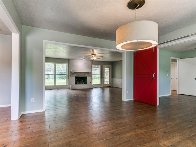 2916 Prairie Rose Ct, Oklahoma City, OK 73120 - unfurnished living room with baseboards, a textured ceiling, hardwood / wood-style floors, a ceiling fan, and healthy amount of natural light