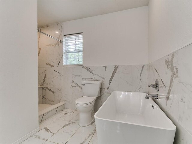 2916 Prairie Rose Ct, Oklahoma City, OK 73120 - full bathroom featuring tile walls, toilet, a freestanding tub, marble finish flooring, and wainscoting