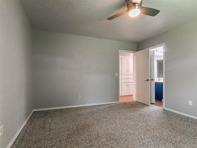 2916 Prairie Rose Ct, Oklahoma City, OK 73120 - unfurnished bedroom featuring carpet floors, a textured ceiling, baseboards, a ceiling fan, and connected bathroom