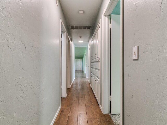 2916 Prairie Rose Ct, Oklahoma City, OK 73120 - hallway featuring wood-type flooring, baseboards, and a textured wall