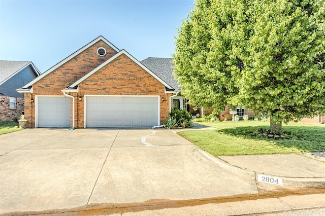 2804 NW 158th St, Edmond, OK 73013 - view of front of home with driveway, an attached garage, a front yard, and brick siding