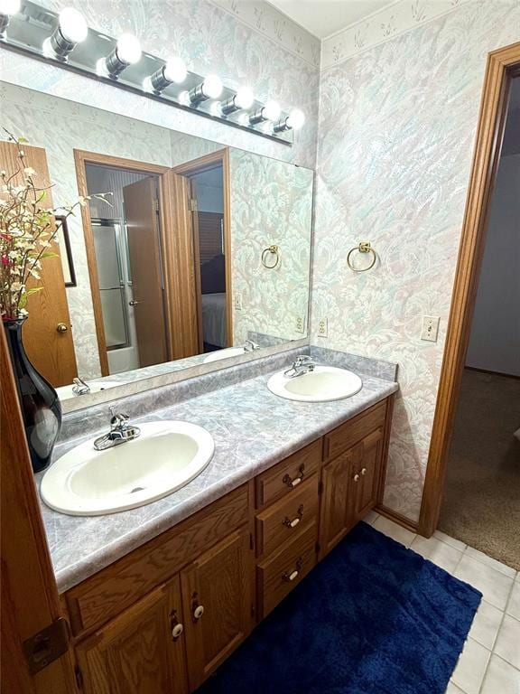 bathroom with wallpapered walls, double vanity, tile patterned floors, and an enclosed shower