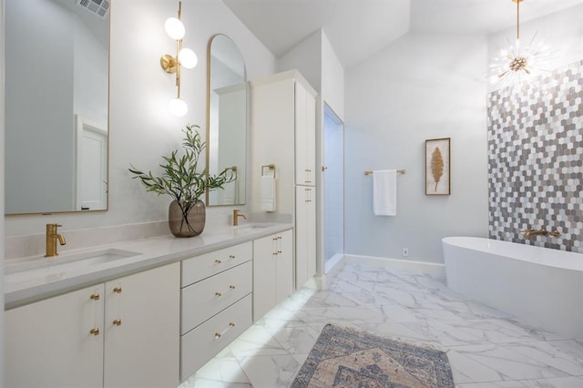 2101 NW 60th St, Oklahoma City, OK 73112 - bathroom featuring a freestanding tub, double vanity, marble finish flooring, lofted ceiling, and baseboards