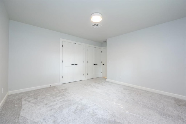 2101 NW 60th St, Oklahoma City, OK 73112 - unfurnished bedroom with two closets, carpet flooring, and baseboards