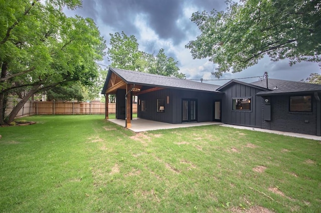 2101 NW 60th St, Oklahoma City, OK 73112 - rear view of property with board and batten siding, a patio area, and a shingled roof