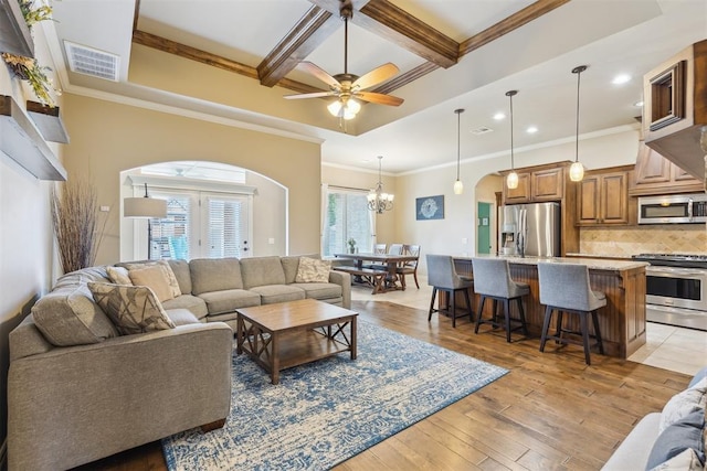 19724 Meadow Bend Ave, Edmond, OK 73012 - living room featuring arched walkways, coffered ceiling, beamed ceiling, recessed lighting, and light wood-type flooring