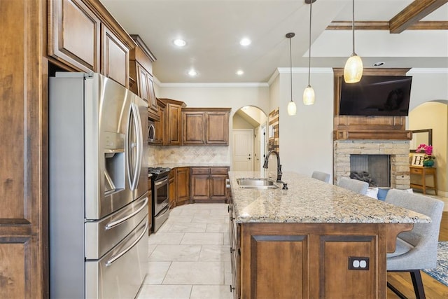 19724 Meadow Bend Ave, Edmond, OK 73012 - kitchen with appliances with stainless steel finishes, a sink, ornamental molding, an island with sink, and a breakfast bar area