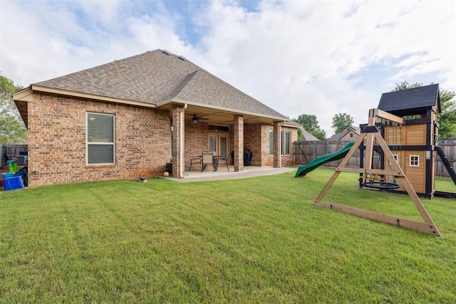 19724 Meadow Bend Ave, Edmond, OK 73012 - rear view of house with a playground, a shingled roof, brick siding, a ceiling fan, and a patio