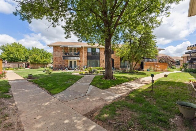 2525 NW 62nd St Unit 208, Oklahoma City, OK 73112 - view of front of property with brick siding, a front yard, and french doors