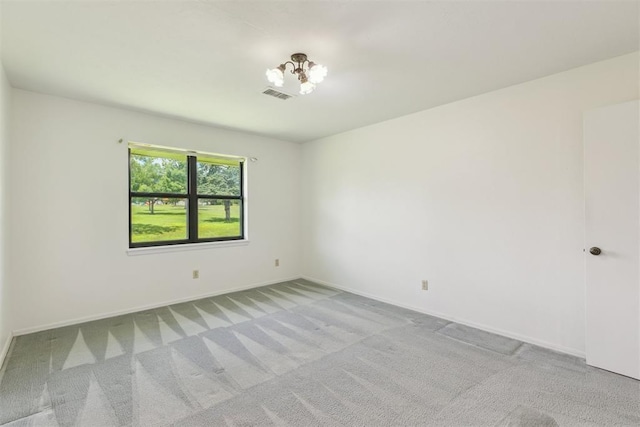 2525 NW 62nd St Unit 208, Oklahoma City, OK 73112 - spare room featuring light colored carpet, baseboards, and a chandelier