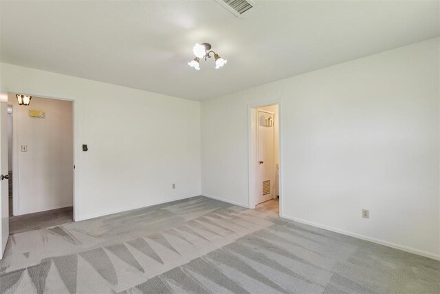 2525 NW 62nd St Unit 208, Oklahoma City, OK 73112 - unfurnished room with light carpet, a chandelier, and baseboards