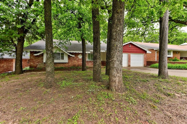 view of front of home featuring brick siding, concrete driveway, and a garage