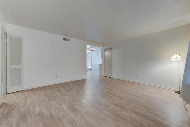 unfurnished living room with light wood-style floors, baseboards, and ceiling fan