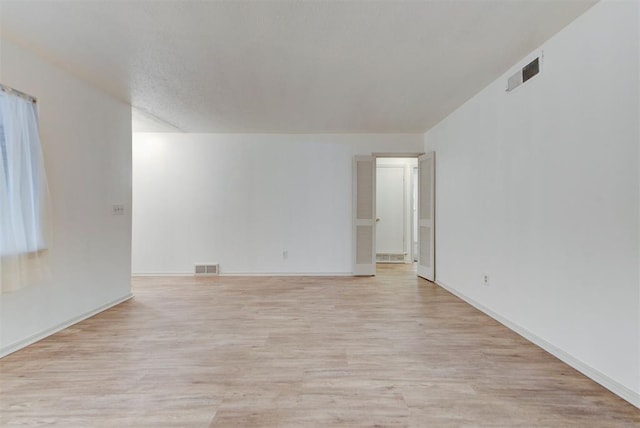empty room with light wood-type flooring and baseboards