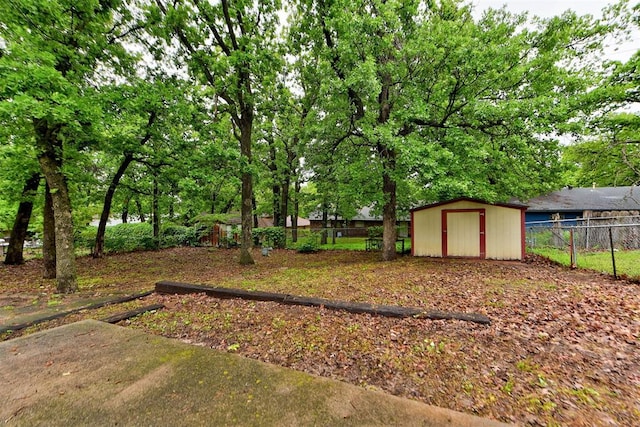 fenced backyard with a storage unit and an outbuilding