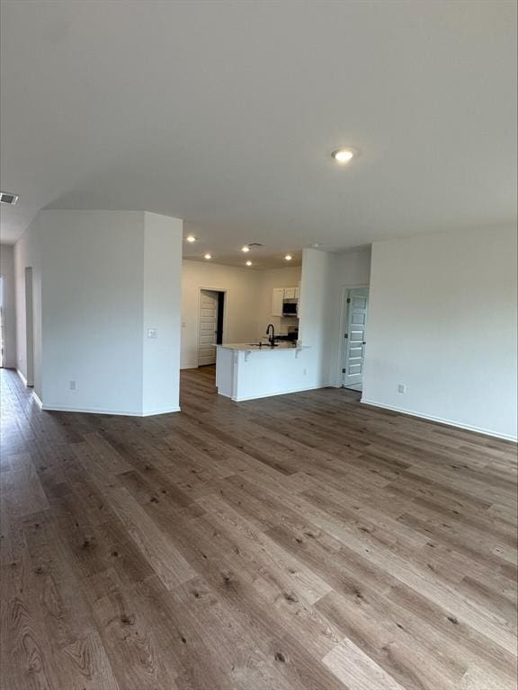 866 SW 11th St, Newcastle, OK 73065 - unfurnished living room featuring a sink, wood finished floors, recessed lighting, and baseboards
