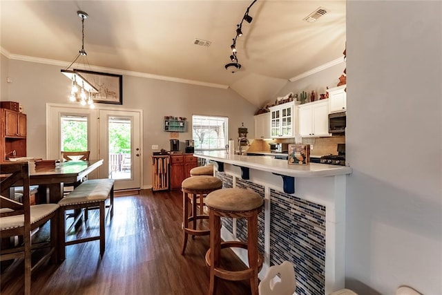 3305 Tecumseh Meadows Way, Norman, OK 73069 - kitchen featuring stainless steel microwave, crown molding, glass insert cabinets, dark wood-style flooring, and decorative backsplash