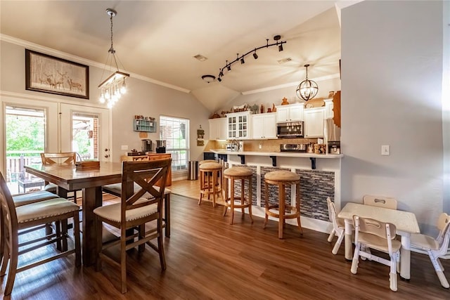 3305 Tecumseh Meadows Way, Norman, OK 73069 - dining space with crown molding, a chandelier, vaulted ceiling, dark wood-style flooring, and track lighting