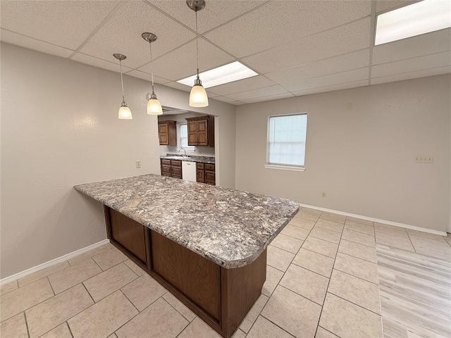 312 N 6th St, Amber, OK 73004 - kitchen featuring a paneled ceiling, a peninsula, baseboards, dishwasher, and light tile patterned flooring