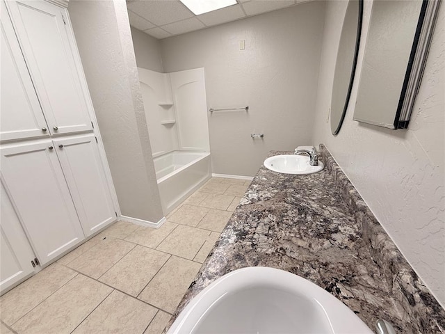 312 N 6th St, Amber, OK 73004 - bathroom featuring tile patterned floors, baseboards, a textured wall, vanity, and bathing tub / shower combination