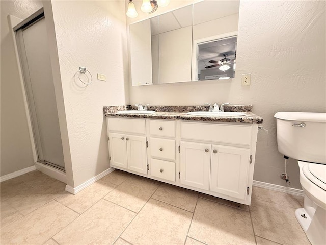 312 N 6th St, Amber, OK 73004 - full bathroom with toilet, a shower stall, baseboards, double vanity, and a ceiling fan