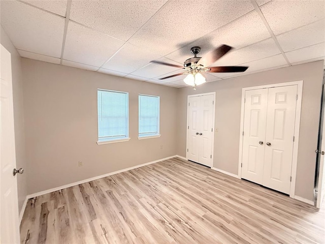 312 N 6th St, Amber, OK 73004 - unfurnished bedroom with light wood-type flooring, baseboards, a drop ceiling, multiple closets, and ceiling fan