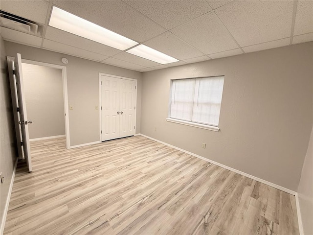 312 N 6th St, Amber, OK 73004 - unfurnished bedroom featuring light wood-type flooring, a paneled ceiling, baseboards, and a closet