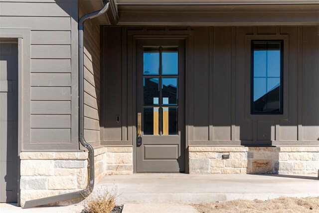 9213 NW 85th St, Yukon, OK 73099 - view of exterior entry featuring board and batten siding and stone siding