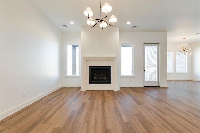 9213 NW 85th St, Yukon, OK 73099 - unfurnished living room featuring a chandelier, baseboards, light wood finished floors, healthy amount of natural light, and recessed lighting