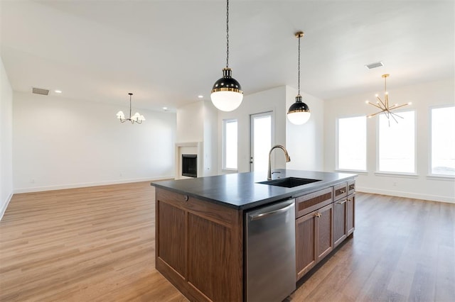 9213 NW 85th St, Yukon, OK 73099 - kitchen with stainless steel dishwasher, a chandelier, a sink, dark countertops, and light wood-style flooring