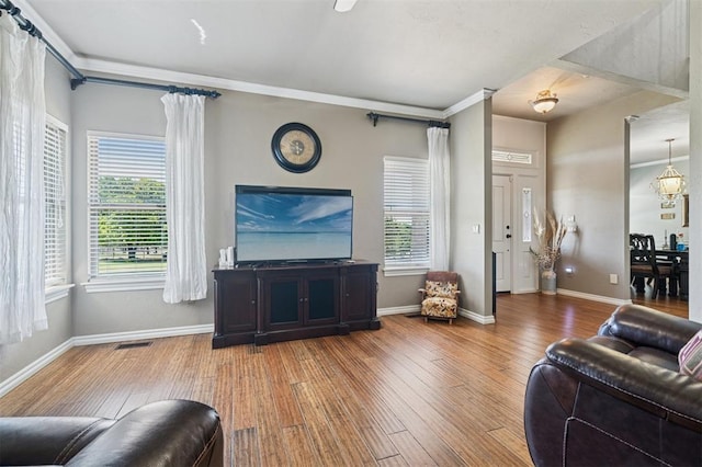 7941 E Sorghum Mill Rd, Edmond, OK 73034 - living area with plenty of natural light, wood finished floors, baseboards, and crown molding