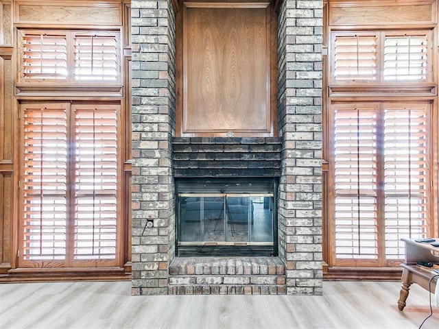 detailed view of wood finished floors and a brick fireplace