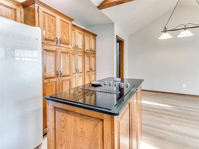 kitchen with freestanding refrigerator, dark countertops, light wood-style flooring, vaulted ceiling, and a center island