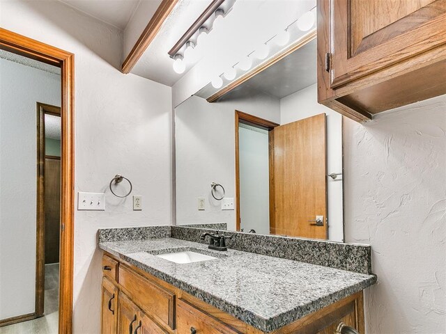 bathroom featuring vanity and a textured wall