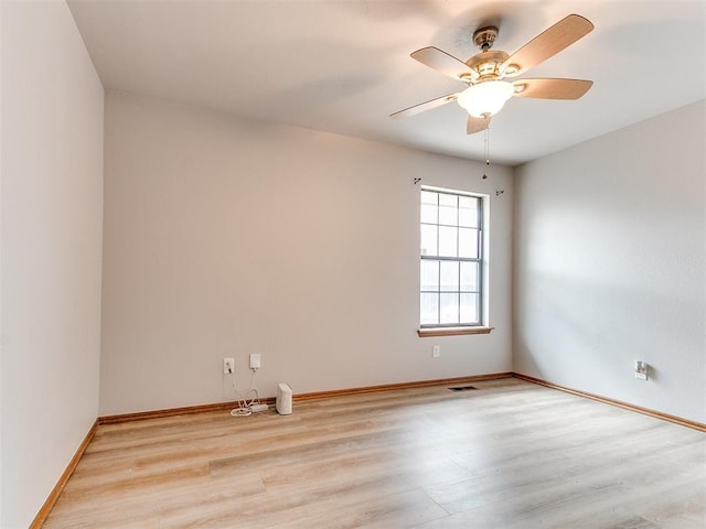 empty room with light wood-style floors, a ceiling fan, and baseboards