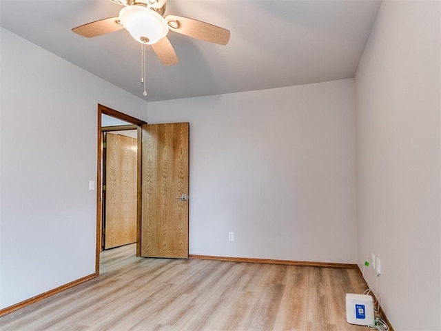 unfurnished room with wood finished floors, baseboards, and a ceiling fan