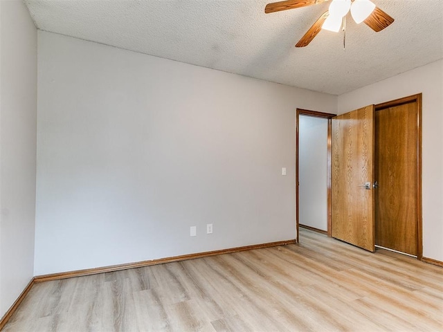unfurnished bedroom featuring light wood-style flooring, baseboards, a textured ceiling, a ceiling fan, and a closet