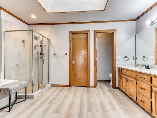 full bathroom with wood finished floors, a stall shower, toilet, ornamental molding, and vanity