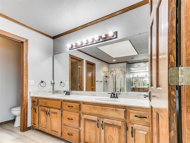 full bathroom with a shower stall, toilet, crown molding, double vanity, and wood finished floors