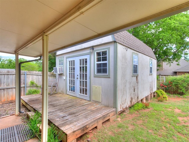 view of outdoor structure featuring fence, french doors, and cooling unit