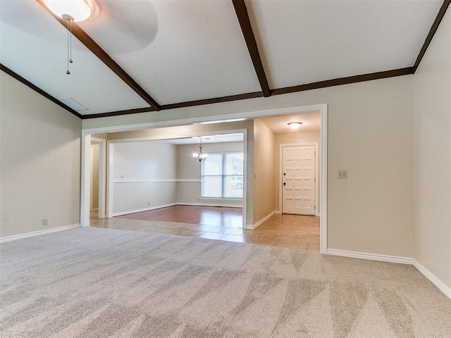 carpeted empty room featuring a chandelier and baseboards