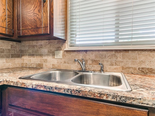 kitchen featuring a sink, decorative backsplash, and light countertops