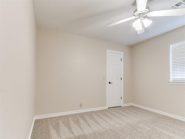 carpeted spare room with ceiling fan and baseboards