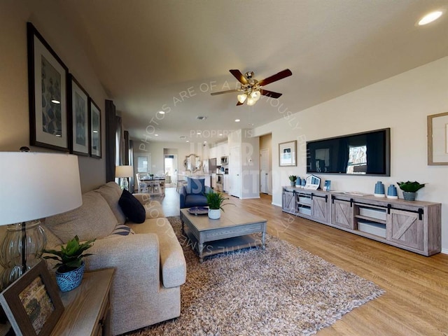 living area with ceiling fan, light wood-style floors, recessed lighting, and baseboards