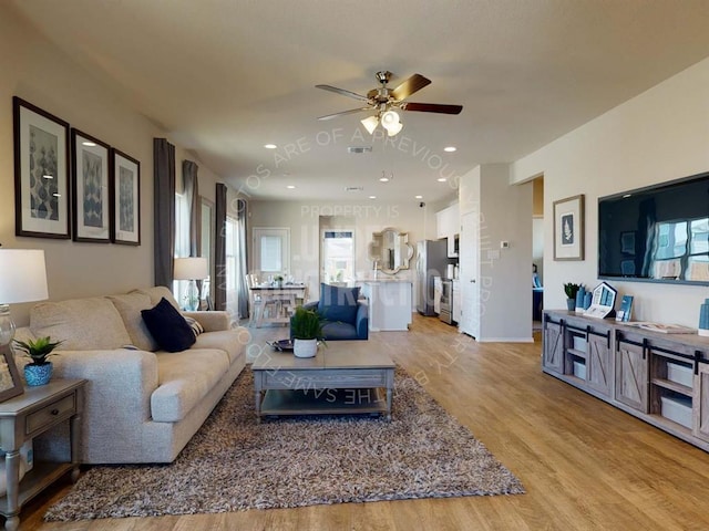 living area featuring a ceiling fan, healthy amount of natural light, and light wood finished floors