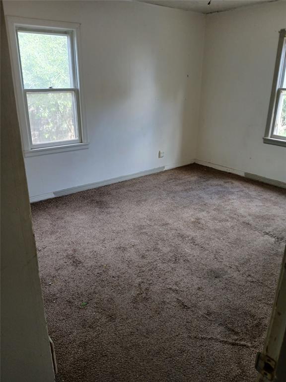 spare room featuring carpet flooring and baseboards