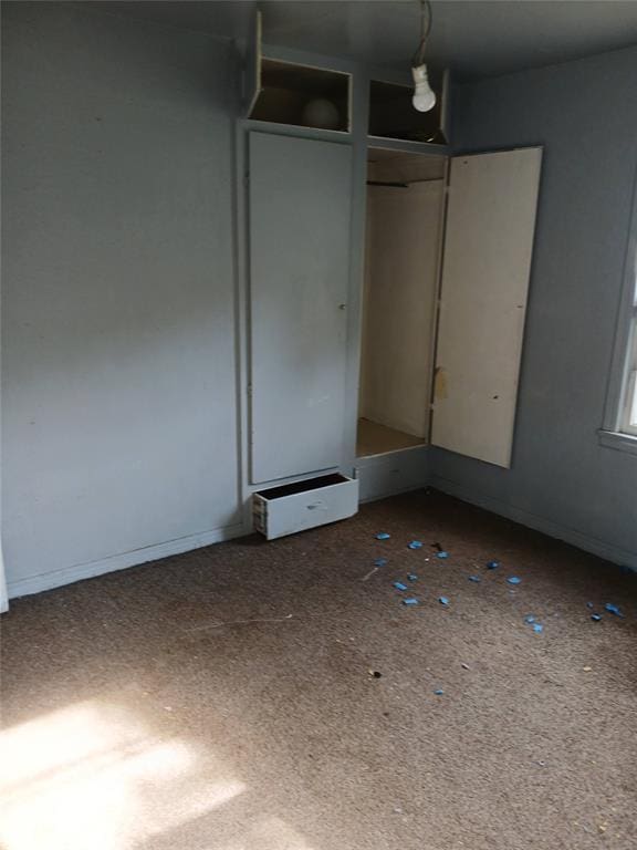 unfurnished bedroom with baseboards and a closet